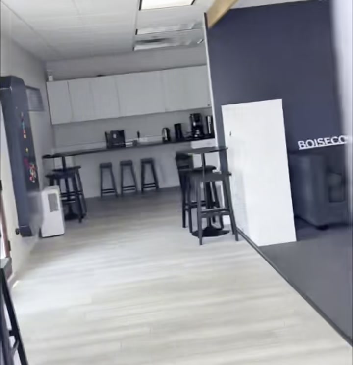 Lobby interior with gray couch, kitchen counter, and BOISECOWORKING.COM sign on the wall