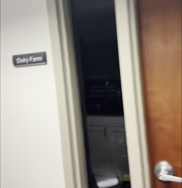Basement hallway approaching the Dutch Oven Conference Room nameplate next to a tile-pattern art piece